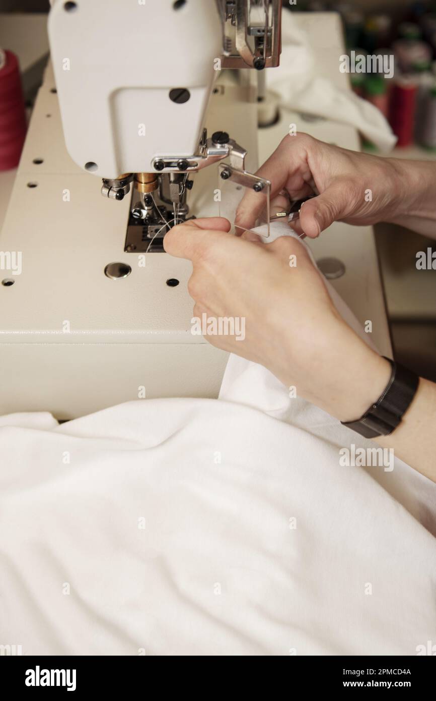 Un tessuto da cucire con cuciture su una macchina da cucire industriale Foto Stock