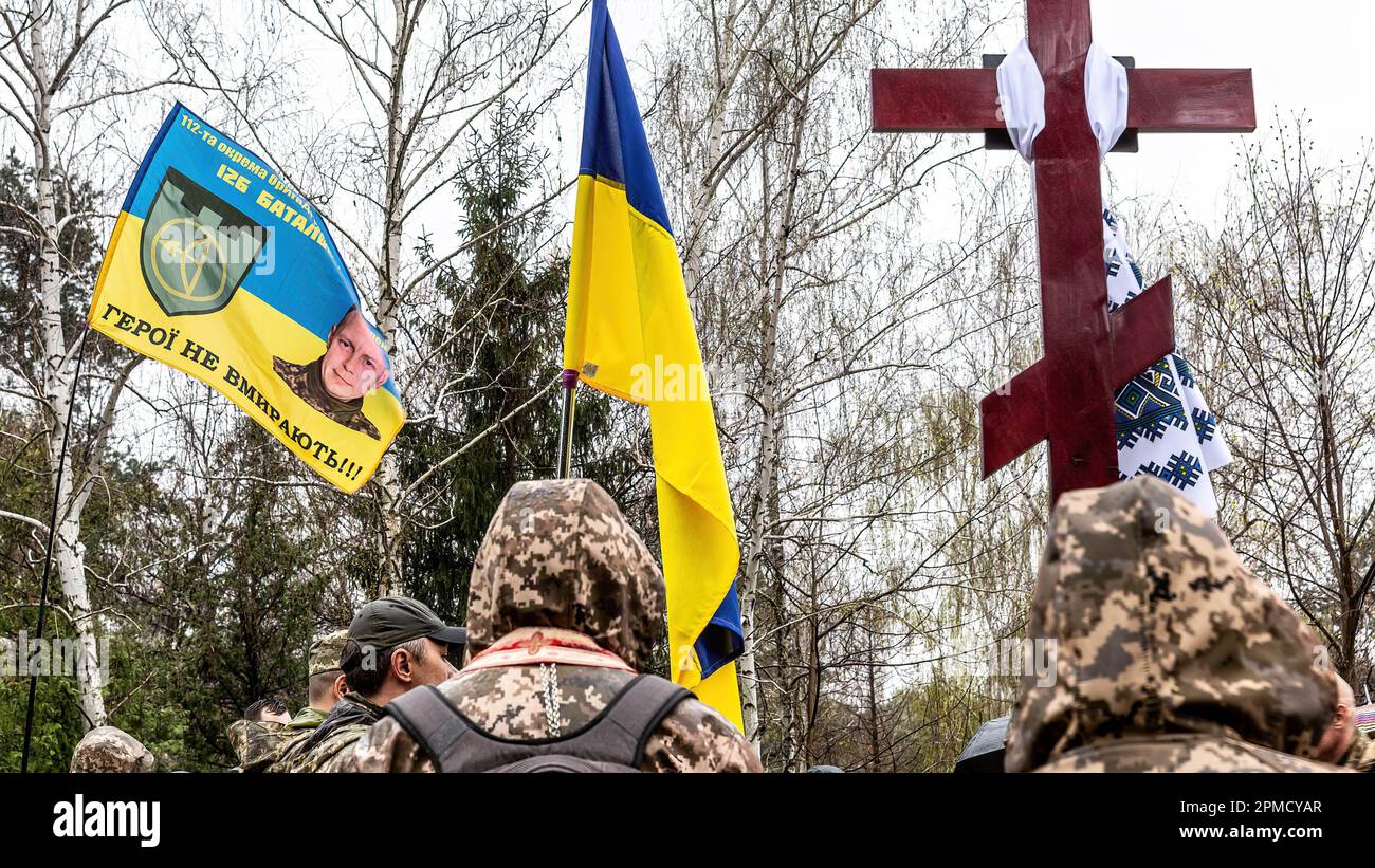 12 aprile 2023, Kiev, Ucraina: Una croce, una bandiera Ucraina e una bandiera battaglione sono visti durante i funerali di Evgeny Yakovlev, 42, un soldato ucciso dalle forze russe sul fronte orientale ucraino in un combattimento, al cimitero di Lisove a Kyiv. Il cimitero di Lisove è il luogo in cui sono sepolti la maggior parte degli uomini dell'esercito caduti di Kiev. Poiché l'invasione su larga scala dell'Ucraina da parte delle forze russe continua, la lotta nell'est dell'Ucraina causa un tasso di incidenti molto elevato, anche se i numeri esatti sono sconosciuti. L'Ucraina si prepara ad un'offensiva primaverile per riprendere la terra occupata dalla Russia. (Credit Image: © Dominika Zarzycka/S Foto Stock