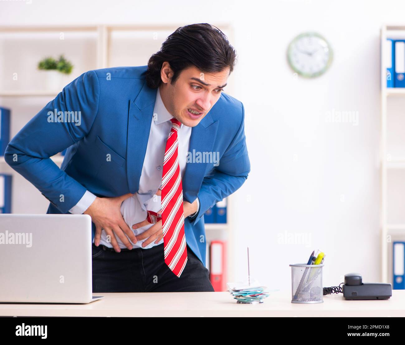 Il giovane maschio sofferenza dei dipendenti in ufficio Foto Stock