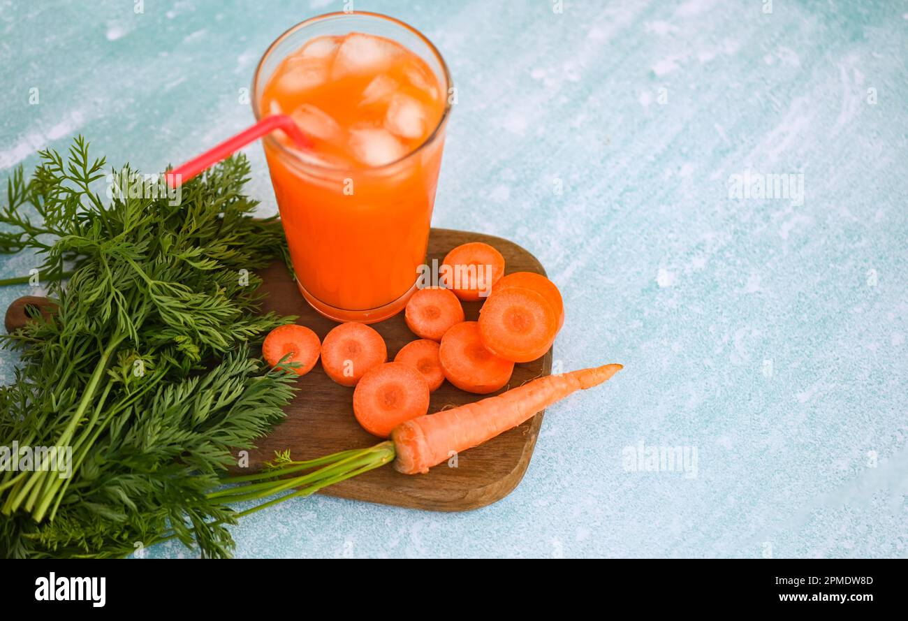 succo di carota su fondo di tavola in legno, fette di carota fresche e dolci per cucinare cibi frutta e verdura per concetto di salute, succo di carote fresche Foto Stock