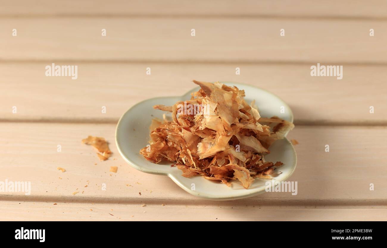 Katsuobushi secchi fiocchi di Bonito su tavolo di legno, spazio copia Foto Stock