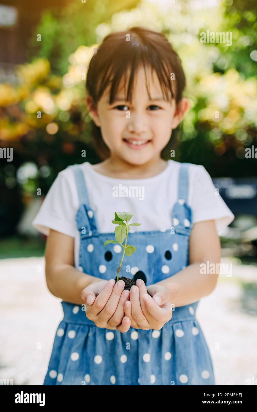 Cute capretto piantare un albero per aiutare a prevenire il riscaldamento globale o il cambiamento climatico e salvare la terra. Immagine per il concetto di Giornata della Terra Foto Stock