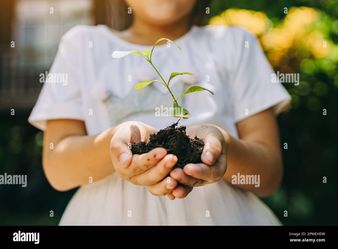Cute capretto piantare un albero per aiutare a prevenire il riscaldamento globale o il cambiamento climatico e salvare la terra. Immagine per il concetto di Giornata della Terra Foto Stock