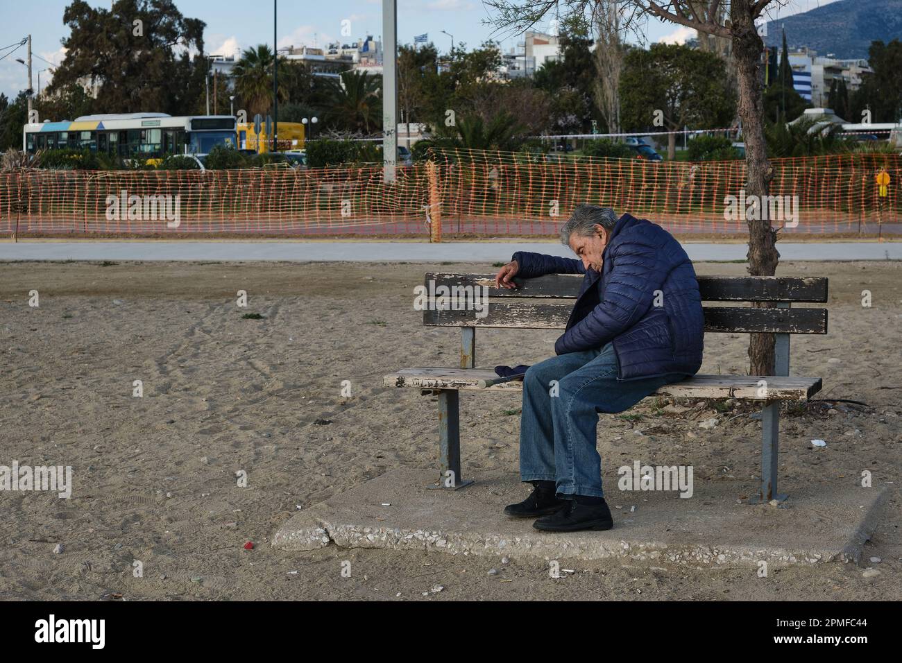 Uomo che dorme a Glyfada Marina, alla periferia di Atene in primavera Foto Stock