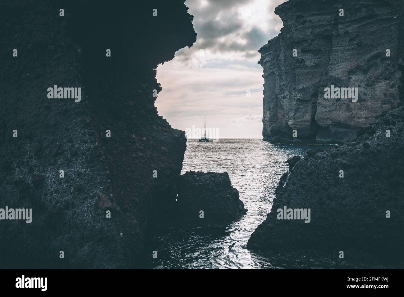 Catamarano a Santorini Caldera attraverso formazioni rocciose al tramonto Foto Stock Catamarano a Santorini Caldera attraverso formazioni rocciose al tramonto Foto Stock