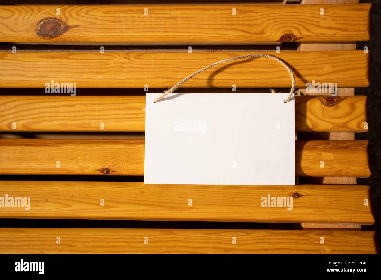 bianco appeso immagine segno su doghe di legno dorato della sedia con spazio libero vuoto per modello o area di copia vuota Foto Stock