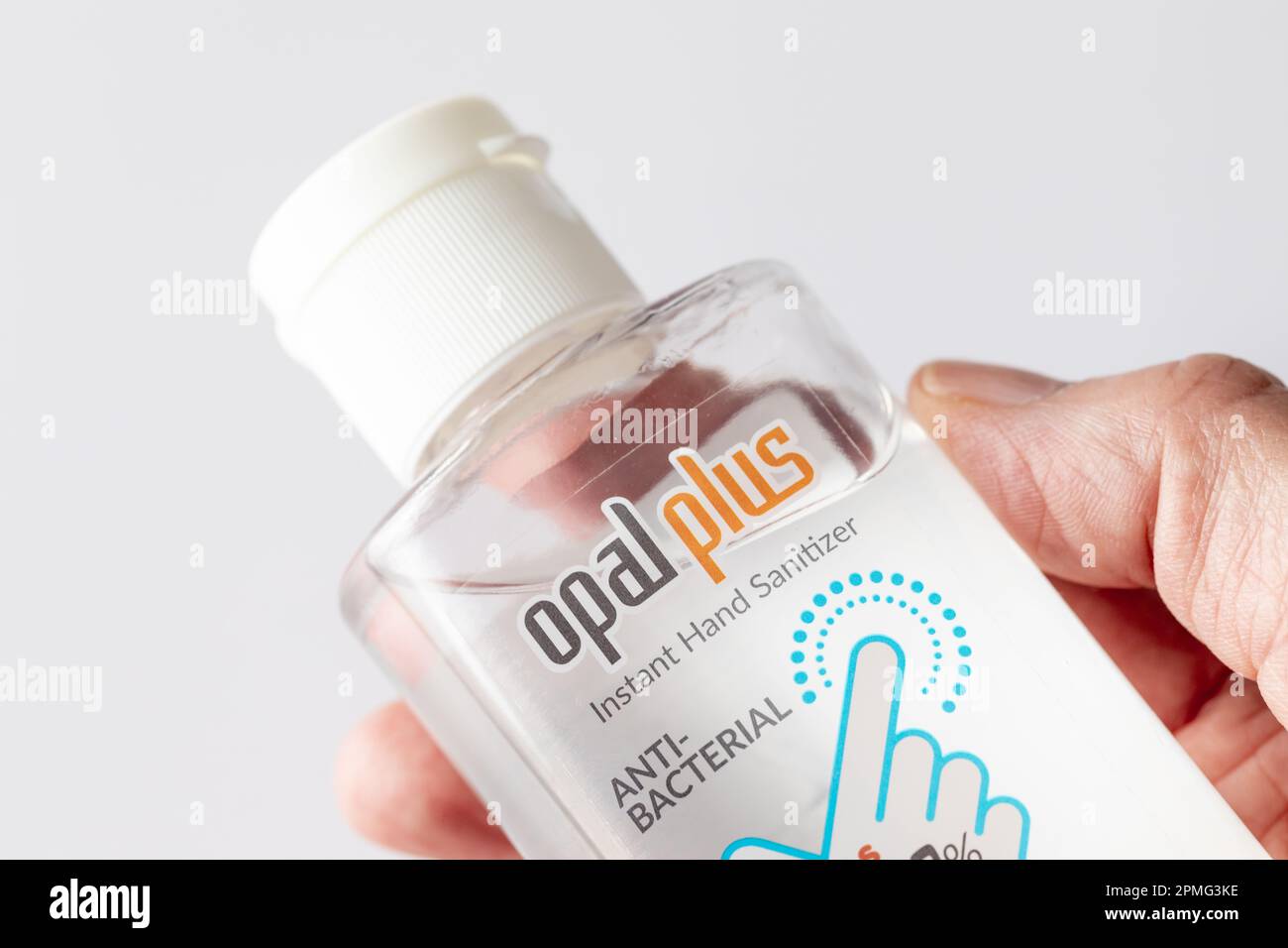 Primo piano di una mano femmina che contiene un flacone di gel igienizzante per le mani. Foto Stock