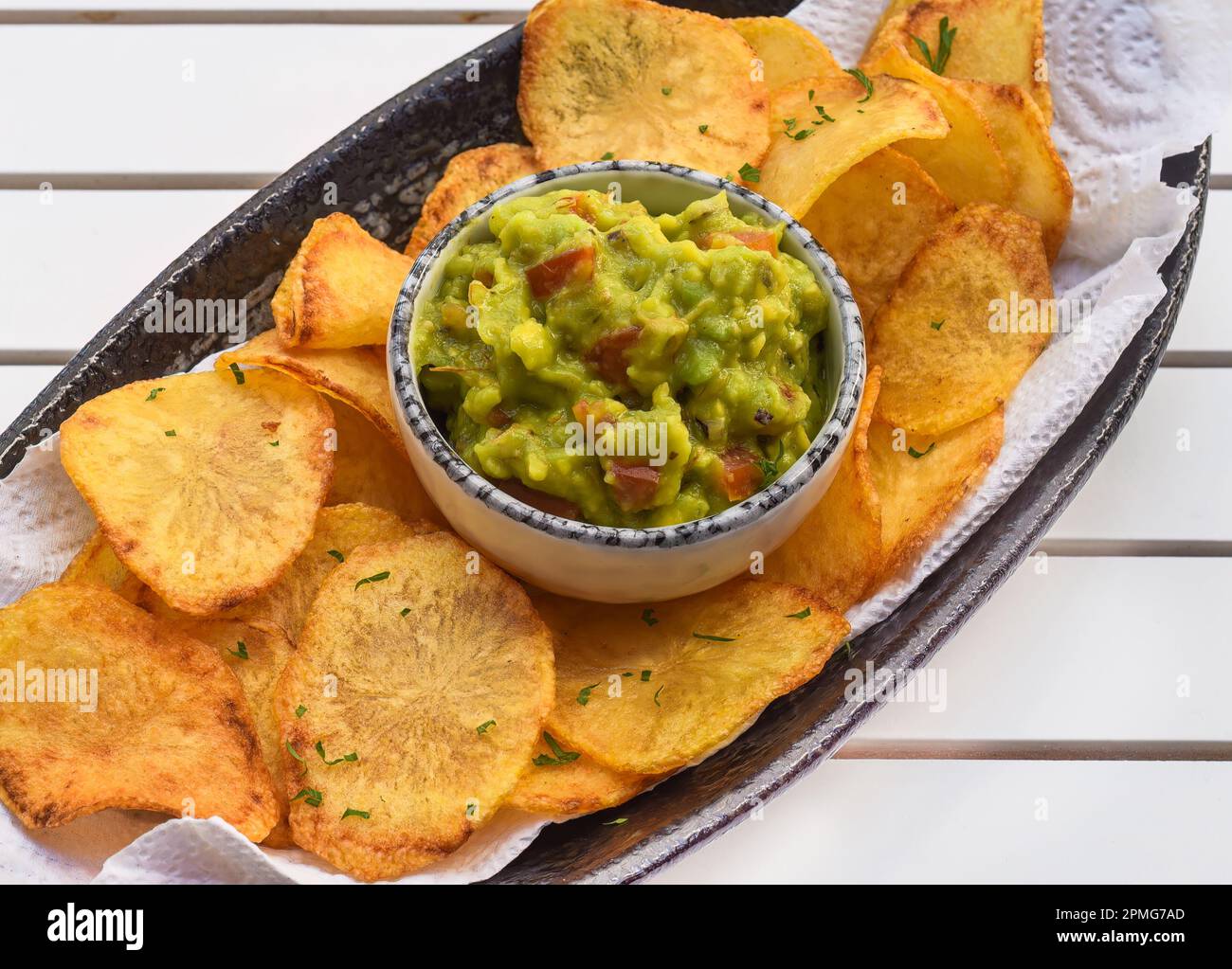 Patatine fatte in casa con salsa vegetariana a base di avocado e verdure su un tavolo di legno bianco Foto Stock