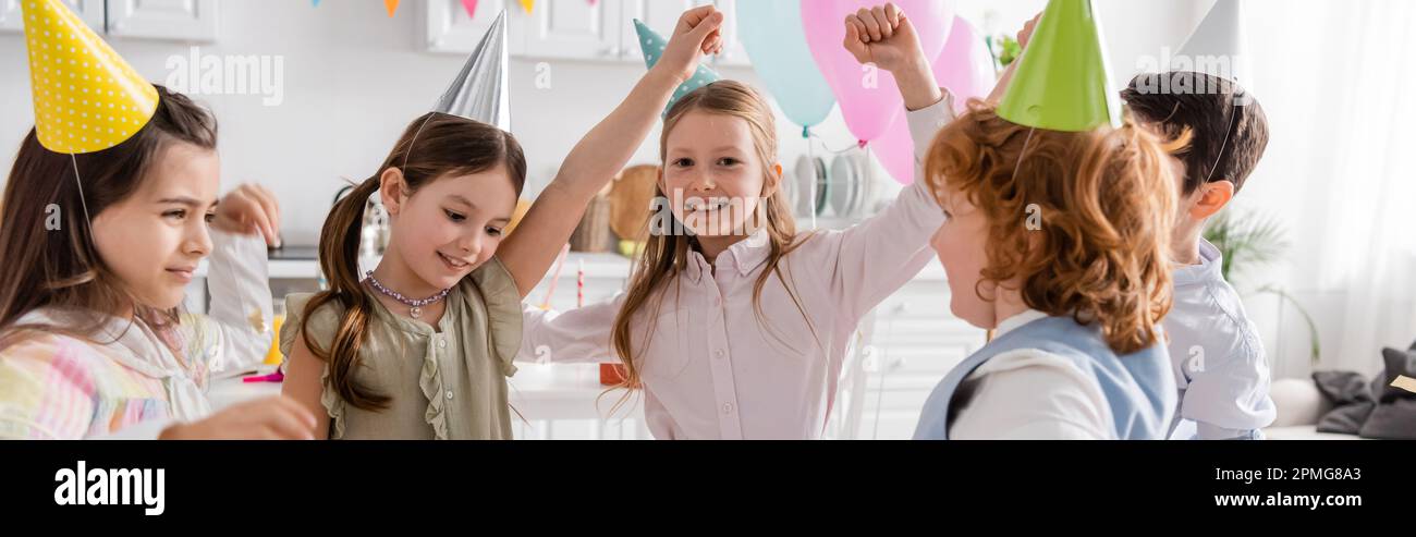 allegri bambini in festa cappellini ballare durante felice compleanno  celebrazione a casa, banner, immagine stock Foto stock - Alamy
