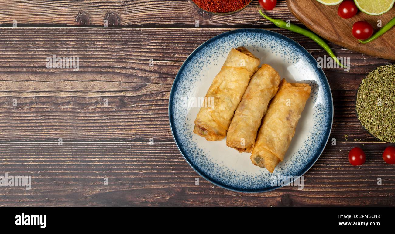 Pasticceria Pacanga su fondo in legno. Pasta di fillo con pastrami. Specialità della cucina turca. nome locale pacanga boregi. Vista dall'alto. Spazio di copia. E Foto Stock