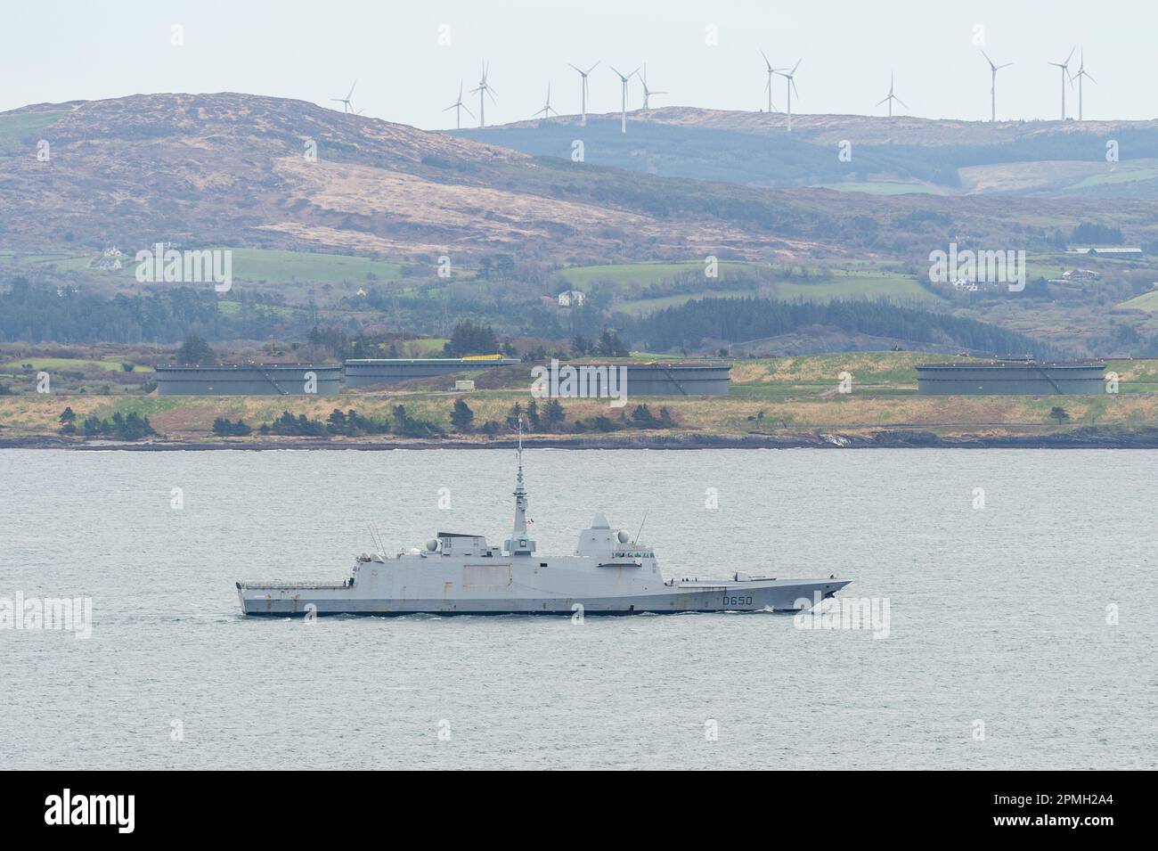 Glengarriff, West Cork, Irlanda. 13th Apr, 2023. La fregata francese della NATO 'Aquitaine', che era stata riparata a Bantry Bay, al largo di Glengarriff, ha navigato verso il mare. La nave da guerra cambiò il suo corso da Oslo, Norvegia, in un luogo non divulgato il lunedì per ripararsi dalla Storm Noa, che colpì la regione il mercoledì. La nave naviga oltre i terminal petroliferi di Whiddy Island. Credit: AG News/Alamy Live News Foto Stock