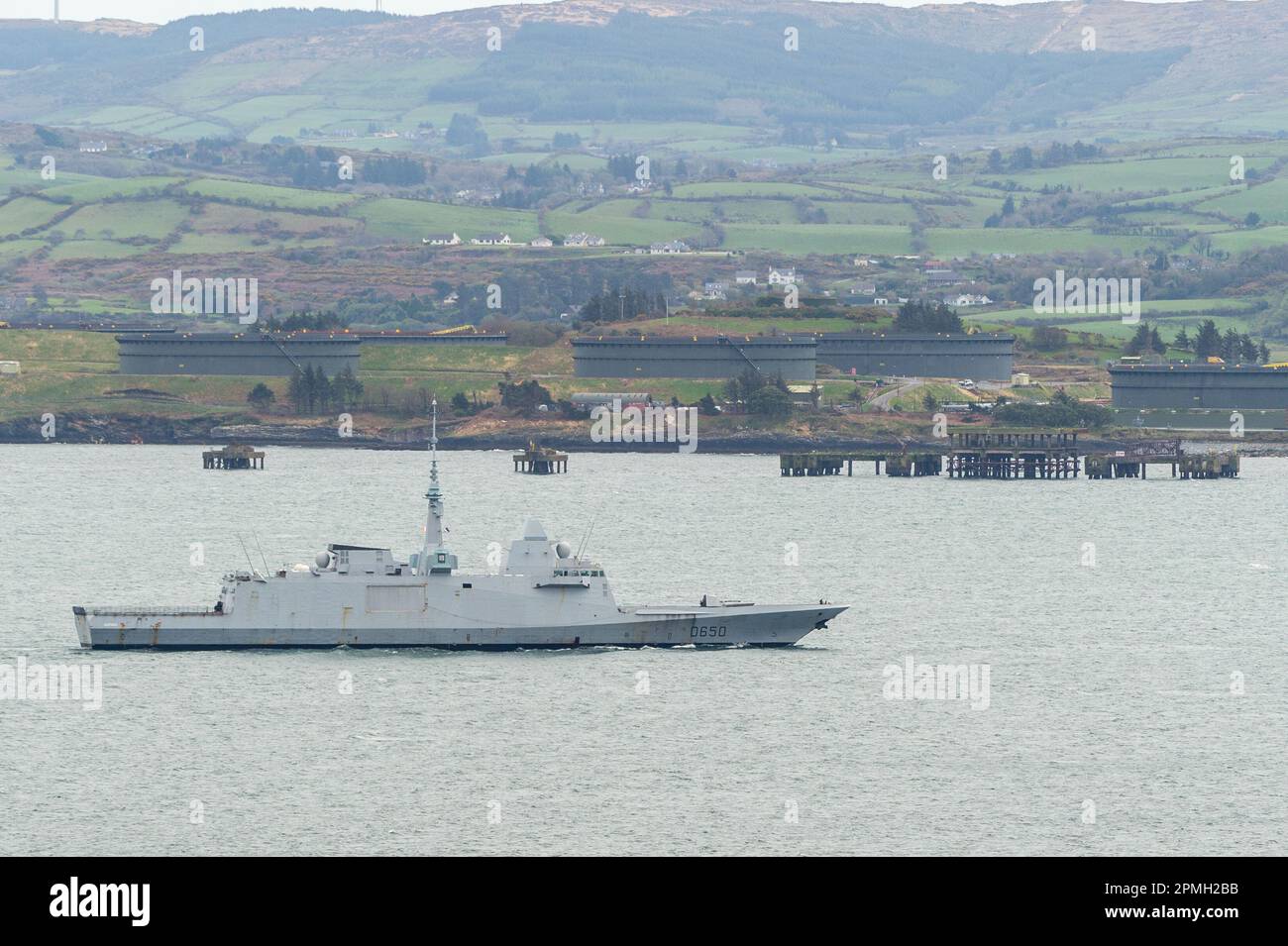 Glengarriff, West Cork, Irlanda. 13th Apr, 2023. La fregata francese della NATO 'Aquitaine', che era stata riparata a Bantry Bay, al largo di Glengarriff, ha navigato verso il mare. La nave da guerra cambiò il suo corso da Oslo, Norvegia, in un luogo non divulgato il lunedì per ripararsi dalla Storm Noa, che colpì la regione il mercoledì. La nave naviga oltre i terminal petroliferi di Whiddy Island. Credit: AG News/Alamy Live News Foto Stock