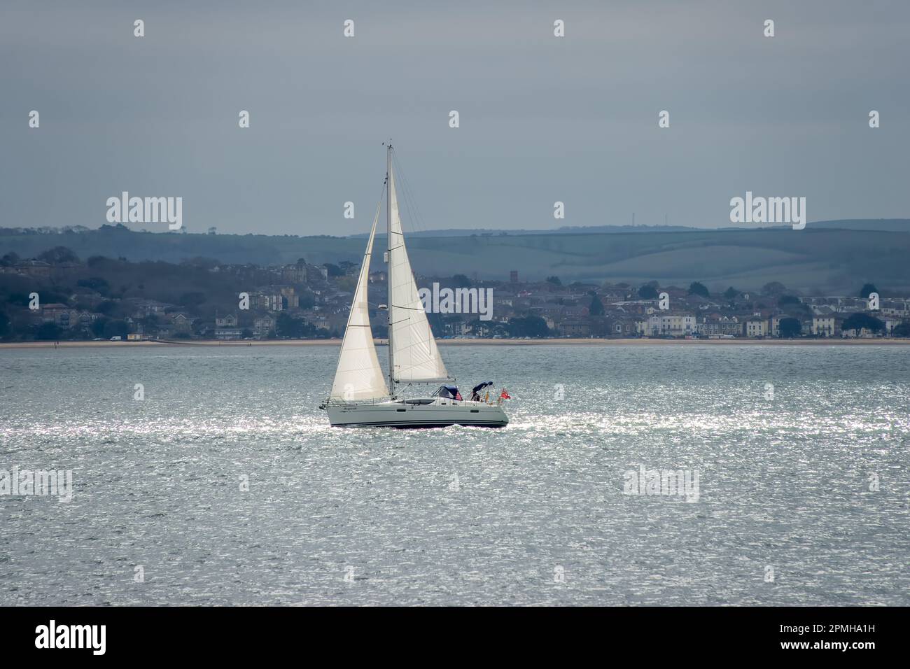 Yacht a vela nel Solent Hampshire Inghilterra con l'Isola di Wight sullo sfondo Foto Stock
