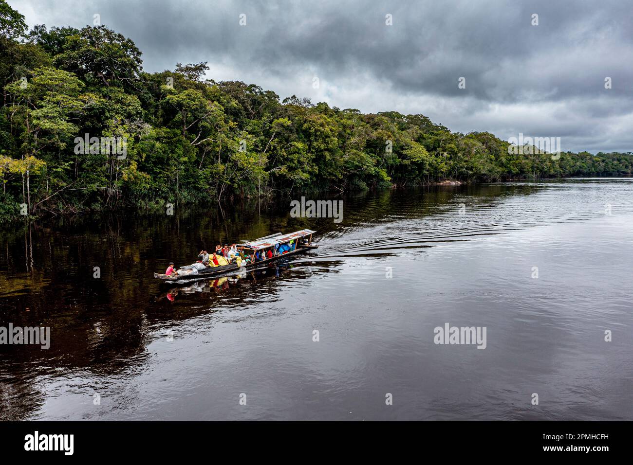 Minatori illegali sulla loro barca sul fiume Pasimoni nero, nel profondo sud del Venezuela, Sud America Foto Stock