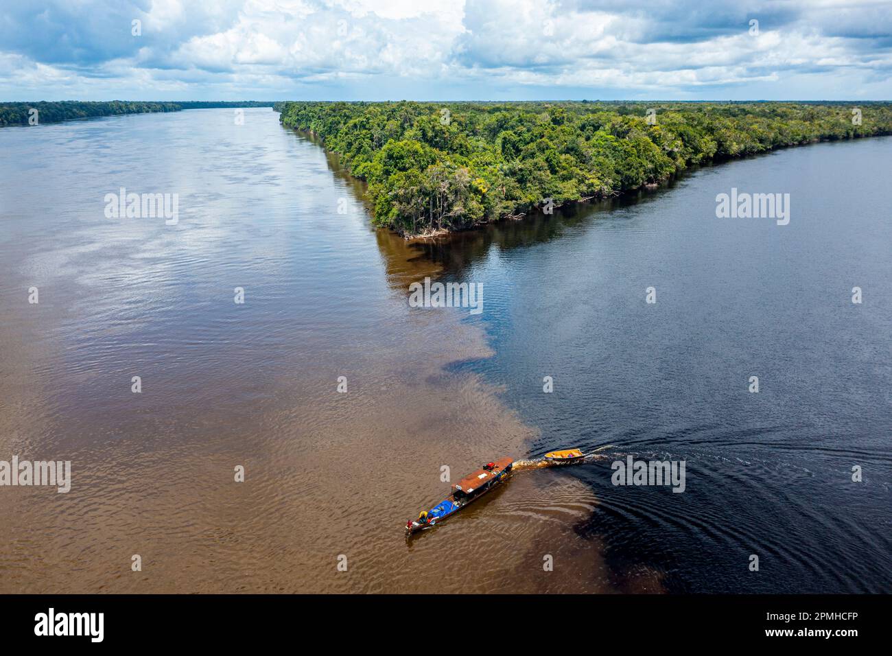 Piccola barca sul punto d'incontro del fiume Casiquiare e del fiume Pasimoni nero, nel profondo sud del Venezuela, Sud America Foto Stock