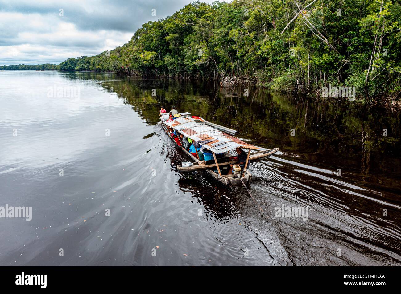 Minatori illegali sulla loro barca sul fiume Pasimoni nero, nel profondo sud del Venezuela, Sud America Foto Stock