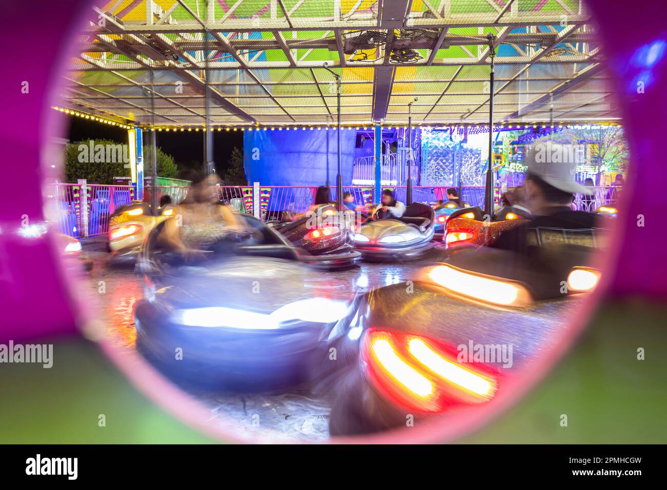 Autoscontri in un carnevale a metà movimento sfocato, come le persone irriconoscibili godersi il viaggio. Foto Stock