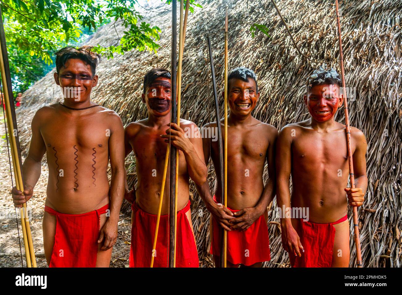 Giovani uomini con il colore sul loro volto che si posano con archi e frecce, tribù Yanomami, Sud del Venezuela, Sud America Foto Stock