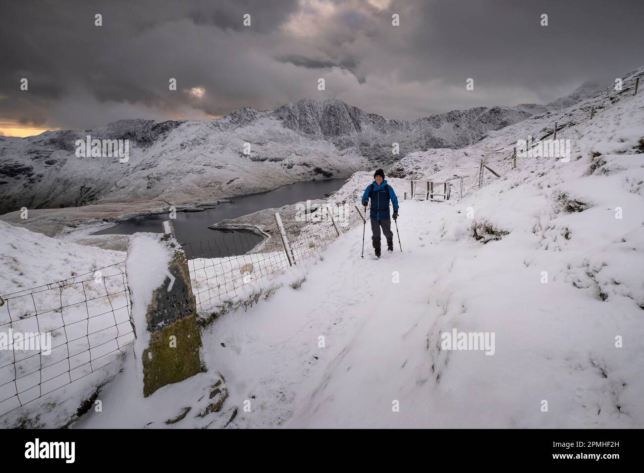 Walker sulla pista PYG sostenuta da CWM Dyli, Llyn Llydaw e Y Llewedd in inverno, Snowdonia National Park, Eryri, Galles del Nord, Regno Unito, Europa Foto Stock