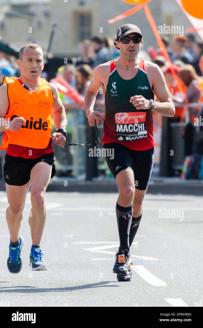 Gabriel Macchi gareggia nella Maratona di Londra 2014, passando attraverso Tower Hill vicino alla Torre di Londra, Regno Unito. Atleta ipovedente con guida Foto Stock