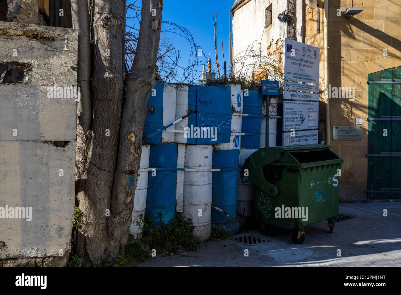Barricate e filo spinato alla linea verde nel sud di Nicosia. Sullo sfondo si possono vedere le cime dei minareti della Moschea Selimiye nel nord della città. Comune di Nicosia, Cipro Foto Stock