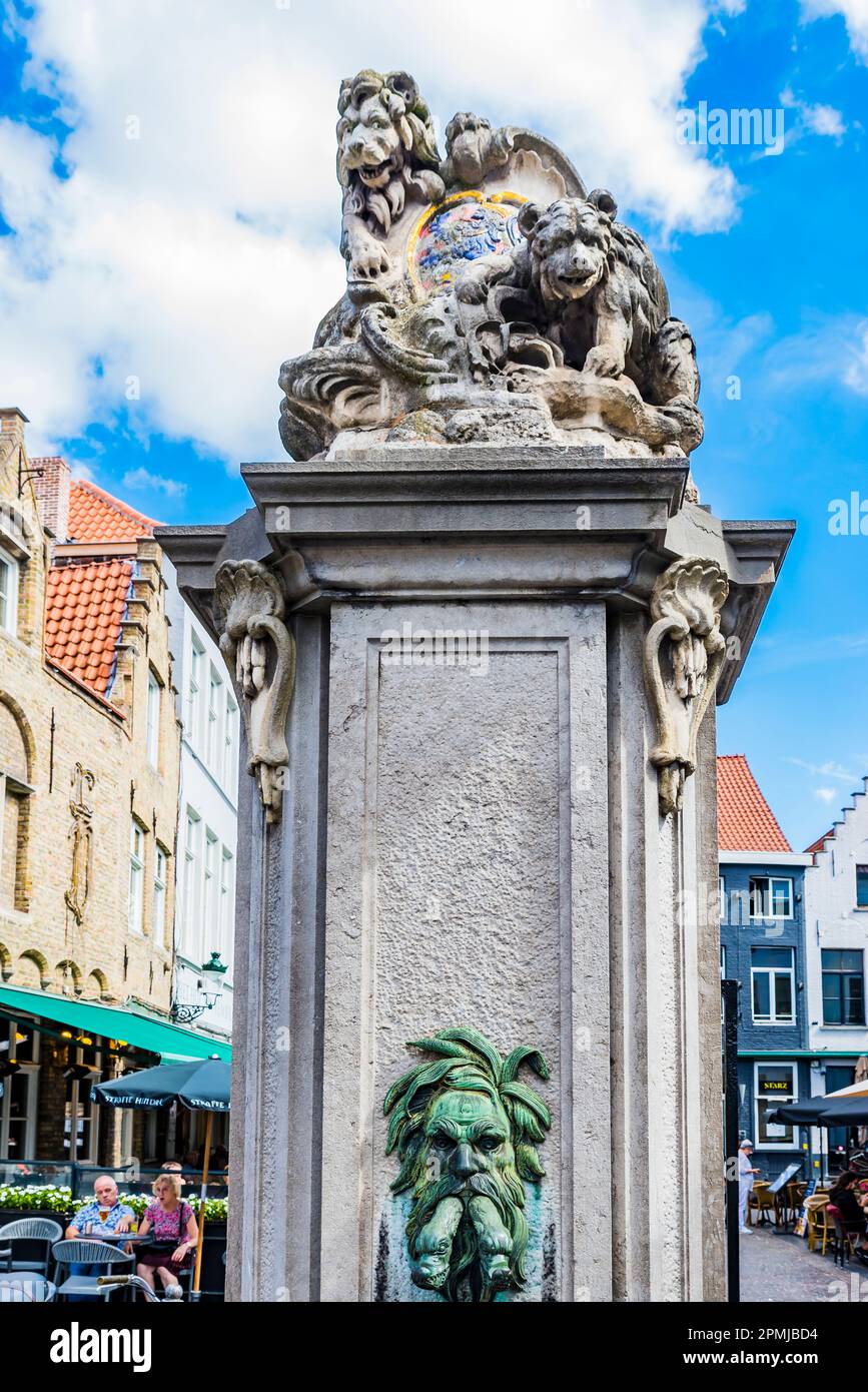 La pompa dell'acqua del 18th ° secolo, una fontana pubblica e una fonte di acqua dolce per la gente di Bruges. Il vivace mercato delle uova, Eiermarkt, una piazza piena o Foto Stock