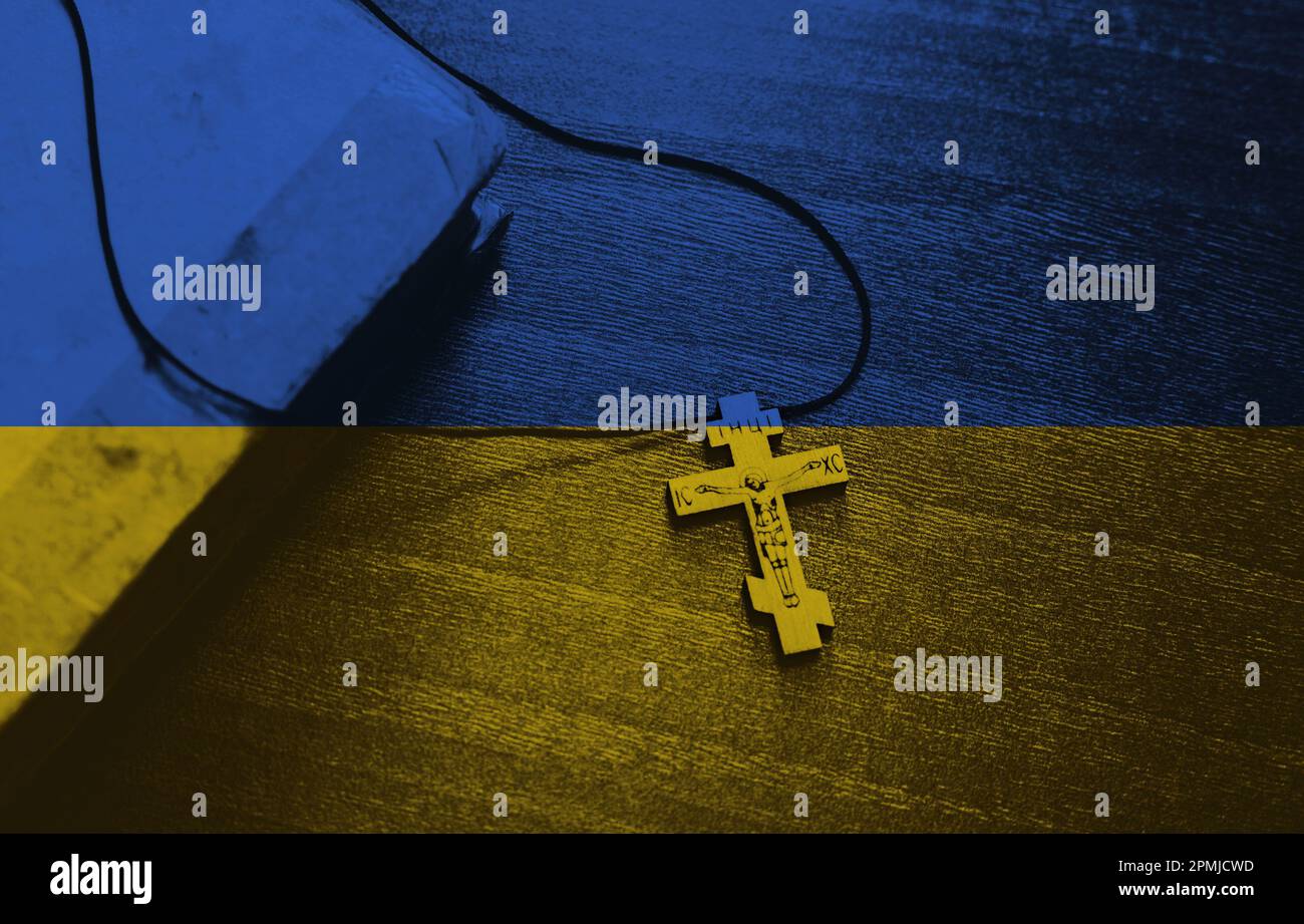 Croce sullo sfondo della bandiera Ucraina. Pregate per l'Ucraina, bandiera Ucraina. Russia vs Ucraina fermare la guerra. Foto Stock