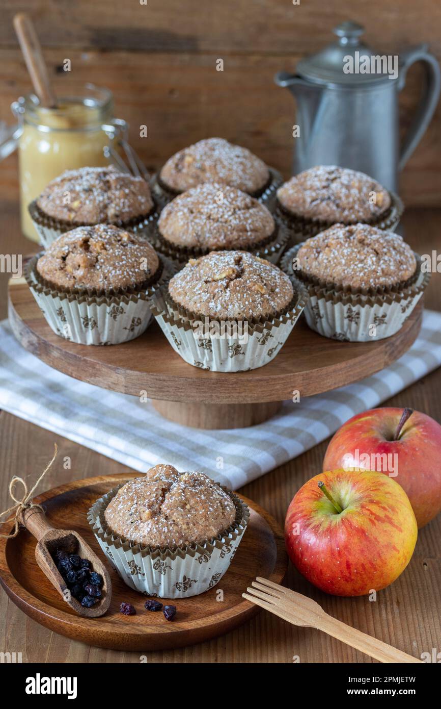 muffin alle mele vegane con ribes zante su un piatto di legno Foto Stock