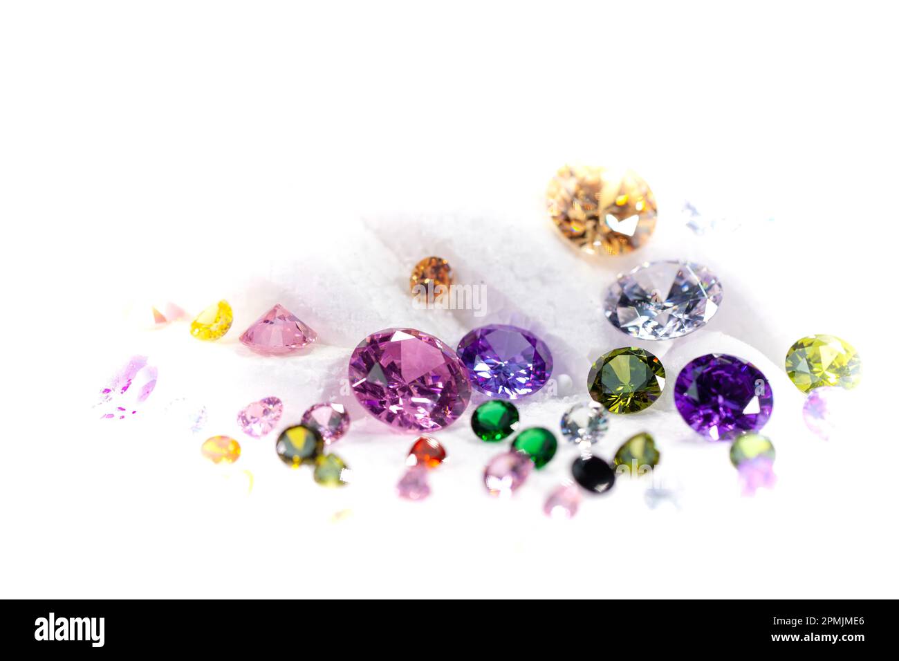 Diamanti colorati su Showcase girando con sfondo nevicante. Pietre e gemme preziose, gioielli. rhinestone e brillante, zaffiro e ametista, aq Foto Stock