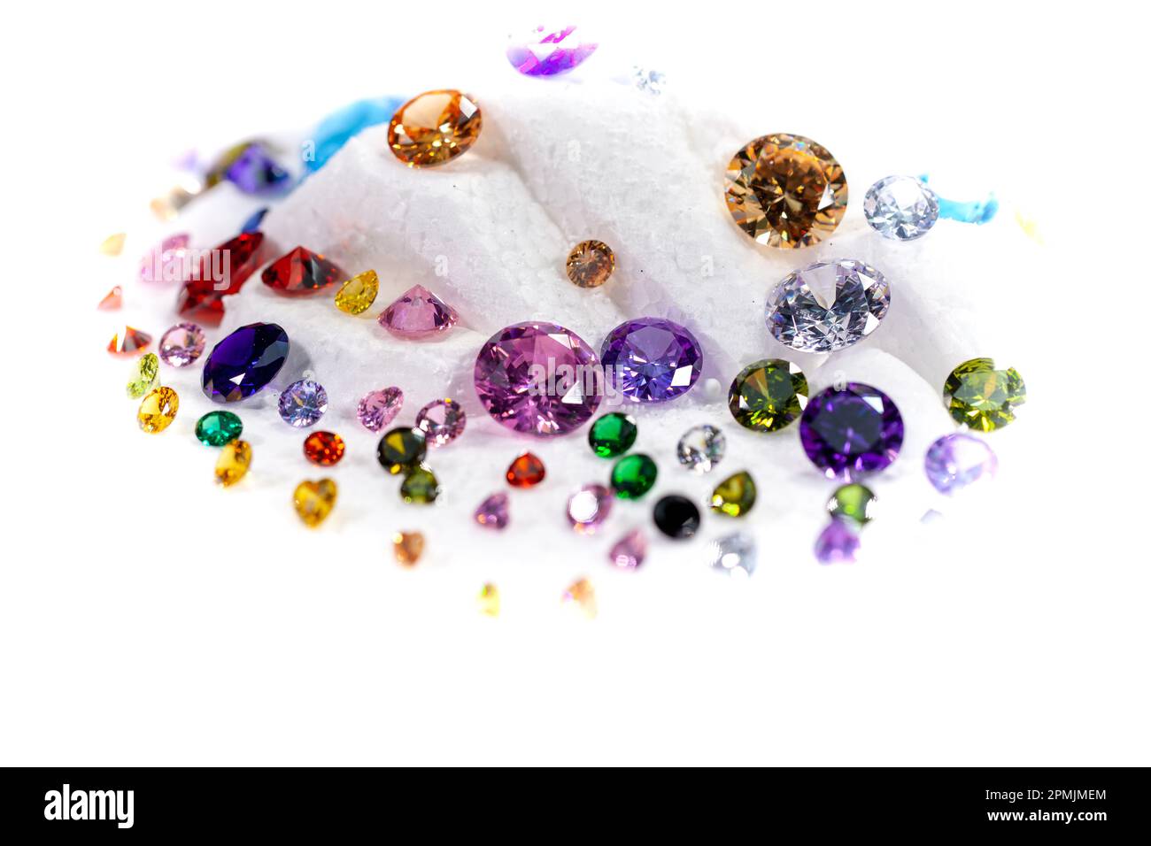 Diamanti colorati su Showcase girando con sfondo nevicante. Pietre e gemme preziose, gioielli. rhinestone e brillante, zaffiro e ametista, aq Foto Stock