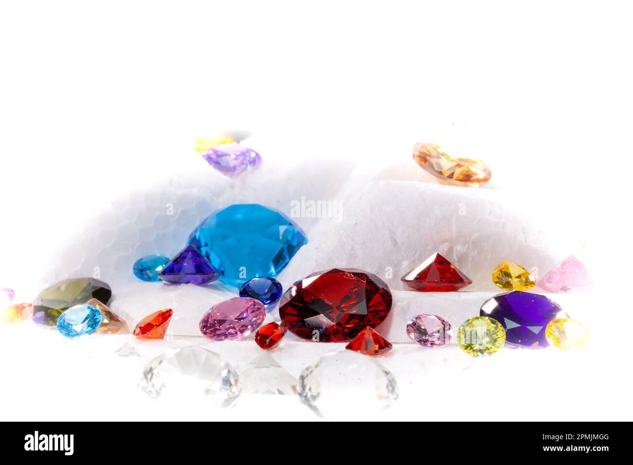 Diamanti colorati su Showcase girando con sfondo nevicante. Pietre e gemme preziose, gioielli. rhinestone e brillante, zaffiro e ametista, aq Foto Stock