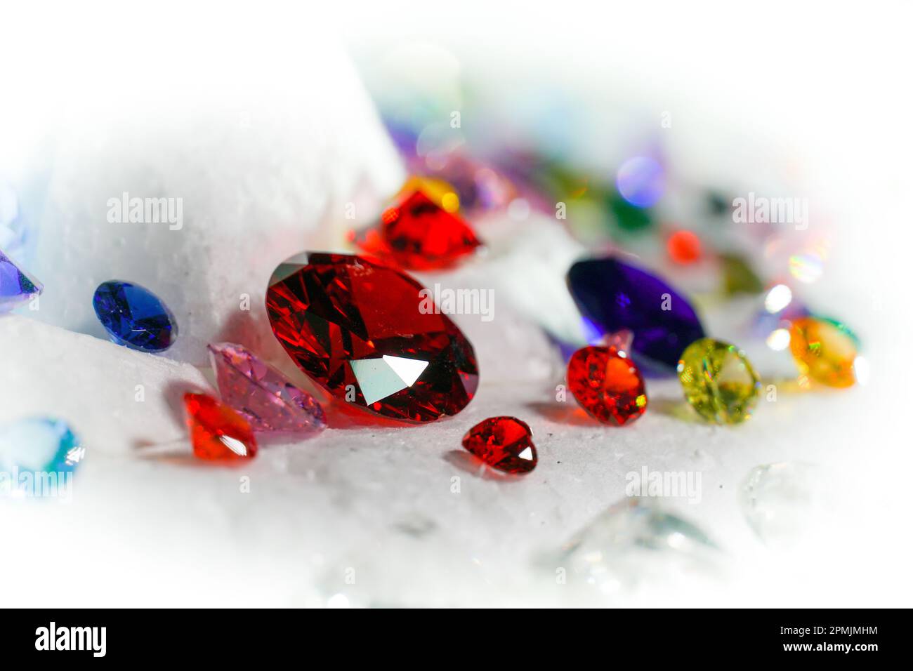 Diamanti colorati su Showcase girando con sfondo nevicante. Pietre e gemme preziose, gioielli. rhinestone e brillante, zaffiro e ametista, aq Foto Stock