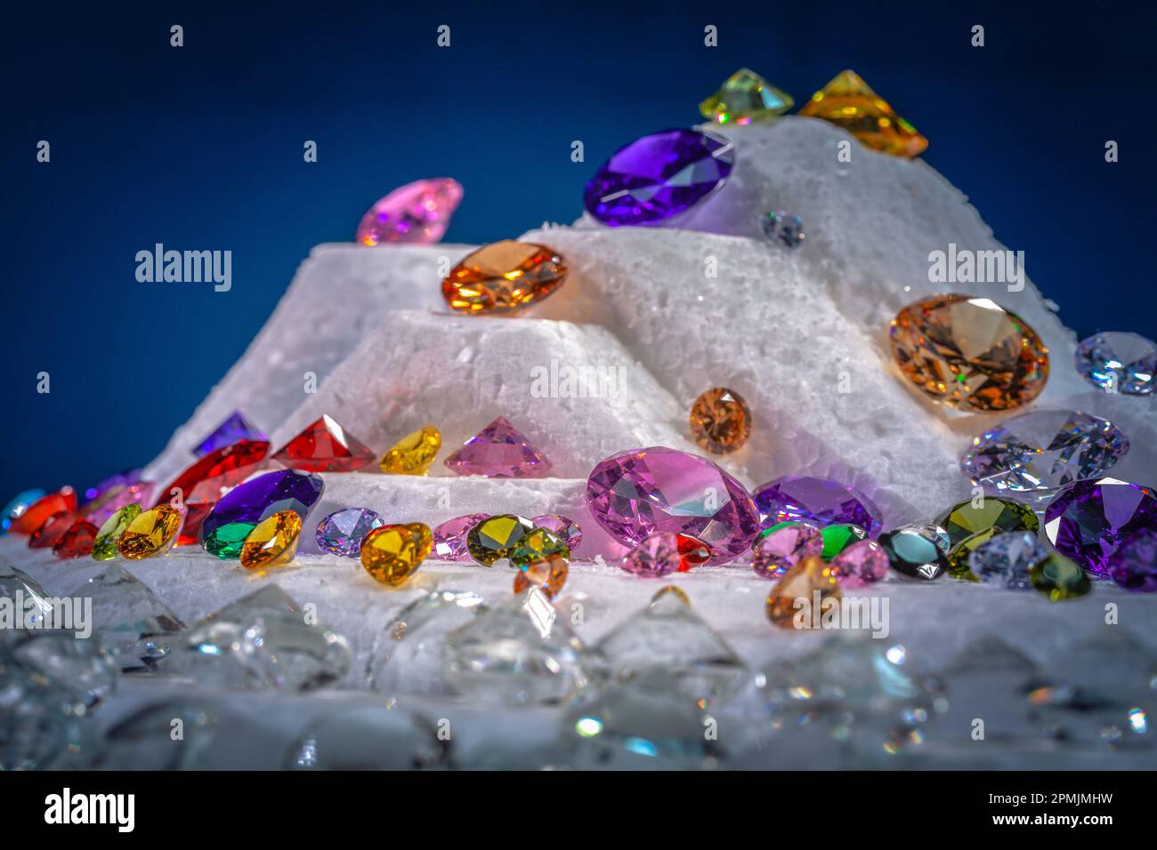 Diamanti colorati su Showcase girando con sfondo nevicante. Pietre e gemme preziose, gioielli. rhinestone e brillante, zaffiro e ametista, aq Foto Stock