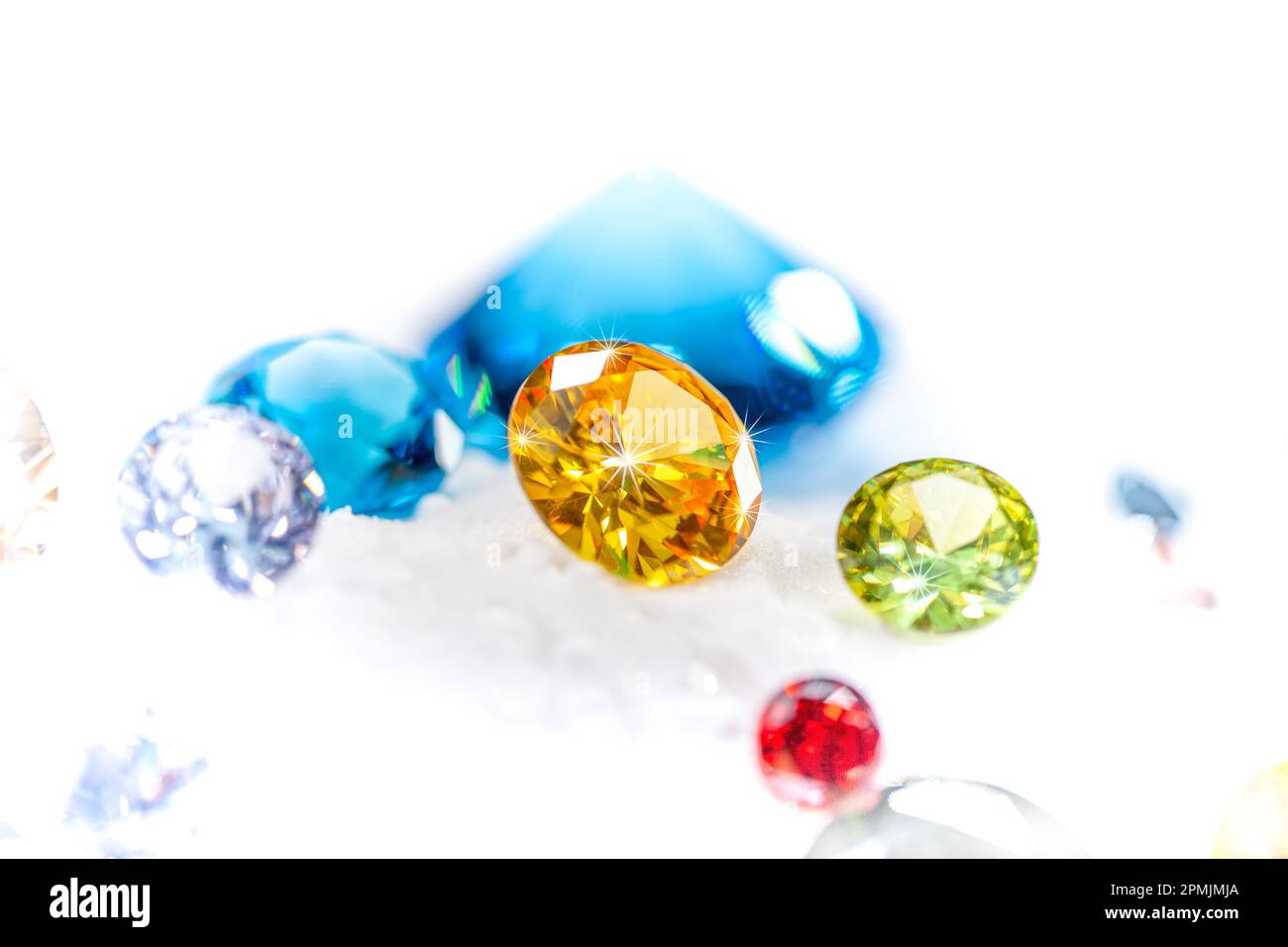 Diamanti colorati su Showcase girando con sfondo nevicante. Pietre e gemme preziose, gioielli. rhinestone e brillante, zaffiro e ametista, aq Foto Stock