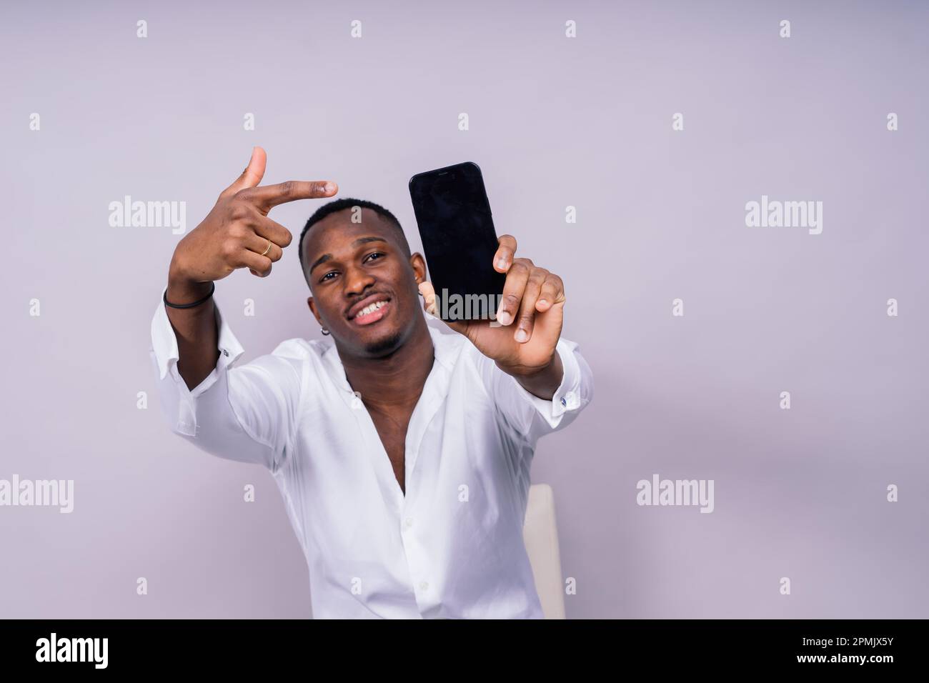 Ottimista afro-americano studente maschio in una camicia casual utilizzando pc portatile isolato Foto Stock