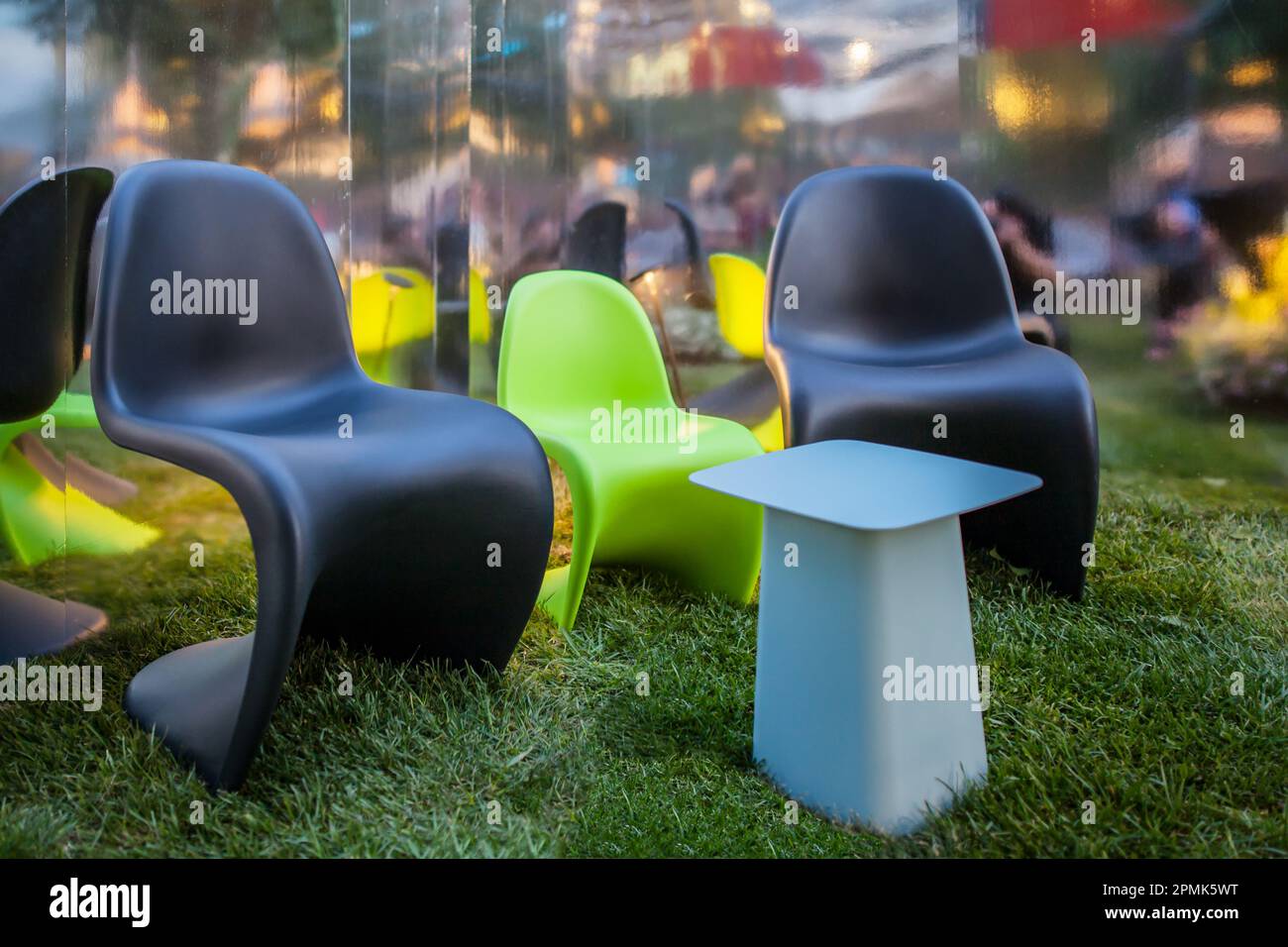 Sedie colorate in plastica dal design moderno per rilassarsi all'aperto sull'erba e nella natura in un'atmosfera tranquilla Foto Stock