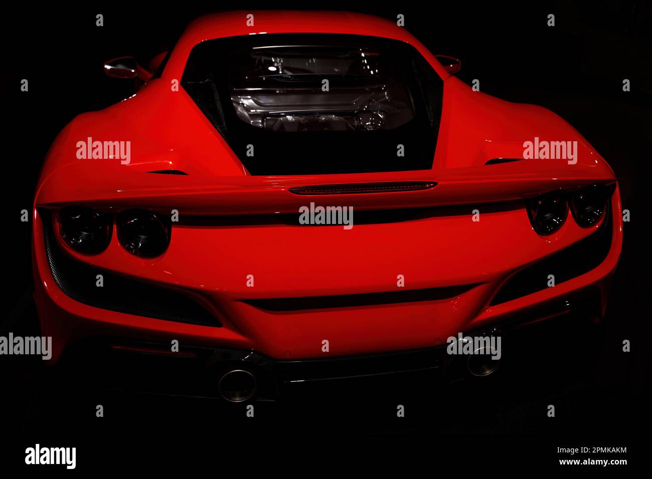 Vista posteriore dell'auto sportiva rossa su sfondo scuro. Foto Stock