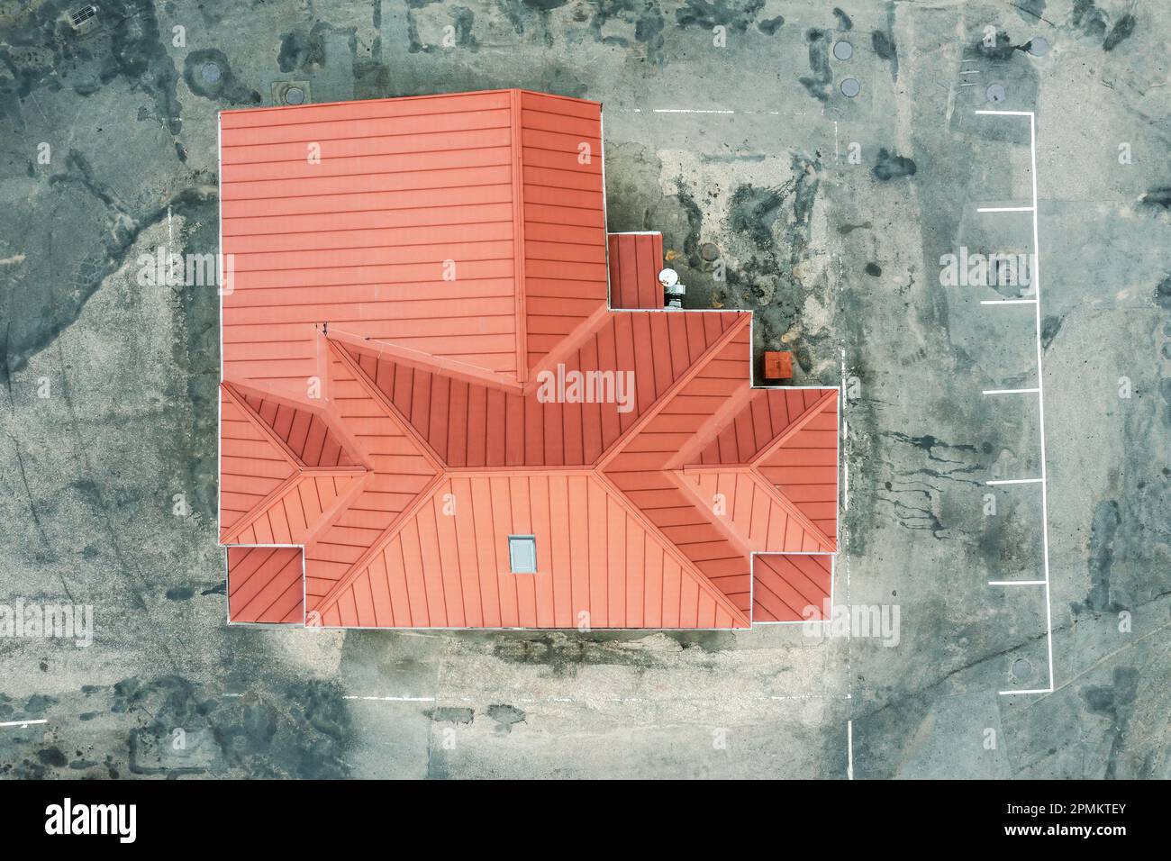 edificio industriale con tetto spiovente in metallo rosso. territorio di un impianto industriale con asfalto sporco. vista dall'alto dell'antenna. Foto Stock