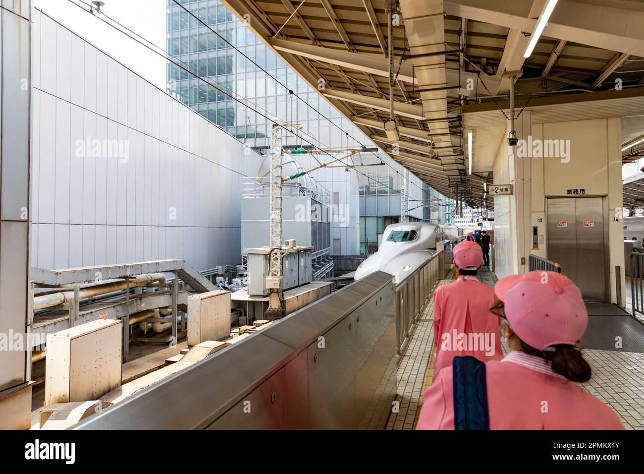 Aprile 2023 i pulitori della stazione ferroviaria di Tokyo aspettano di salire a bordo del treno ad alta velocità Shinkansen per regolare i posti a sedere in direzione del viaggio e pulire il treno, Giappone Foto Stock