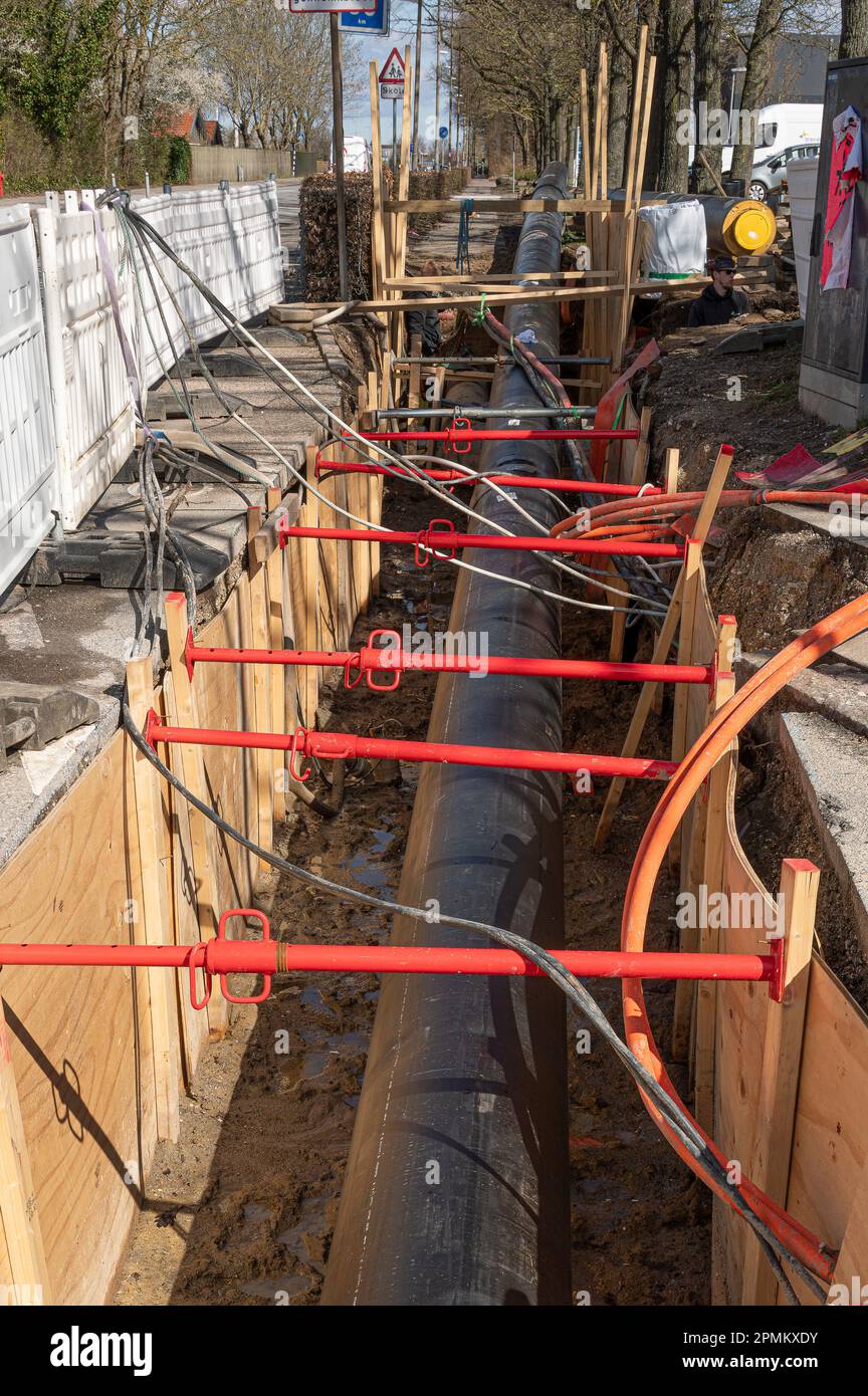 Tubi di teleriscaldamento sepolti in una strada, un cantiere di costruzione a Frederikssund, Danimarca, 13 aprile 2023 Foto Stock