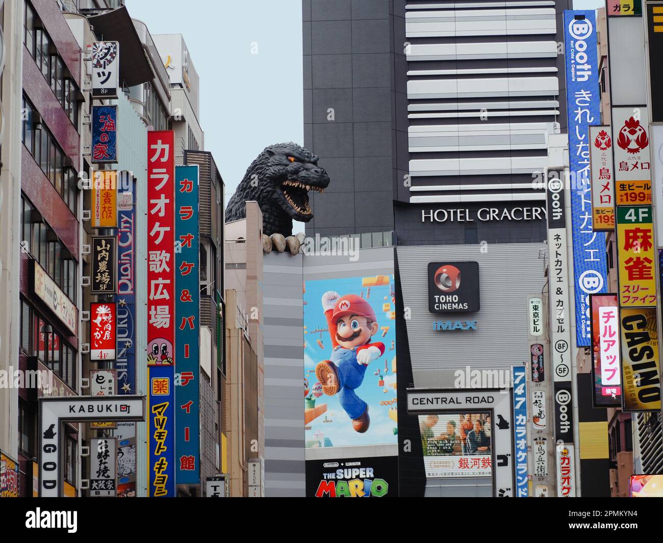 TOKYO, GIAPPONE - 12 aprile 2023: Statua di Godzilla su un cinema Toho a Shinjuku che ha un poster per il Super Mario Bros. Film su di esso. Foto Stock