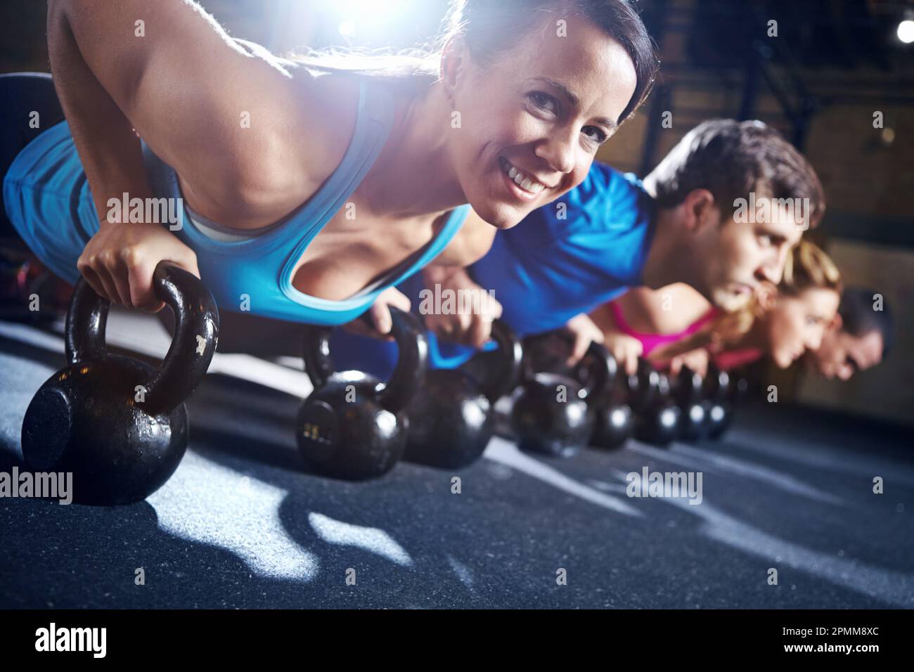 Lavorare in gruppo rafforza la sua determinazione. Un gruppo di giovani uomini e donne che frequentano un corso di allenamento pesi in palestra. Foto Stock Lavorare in gruppo rafforza la sua determinazione. Un gruppo di giovani uomini e donne che frequentano un corso di allenamento pesi in palestra. Foto Stock