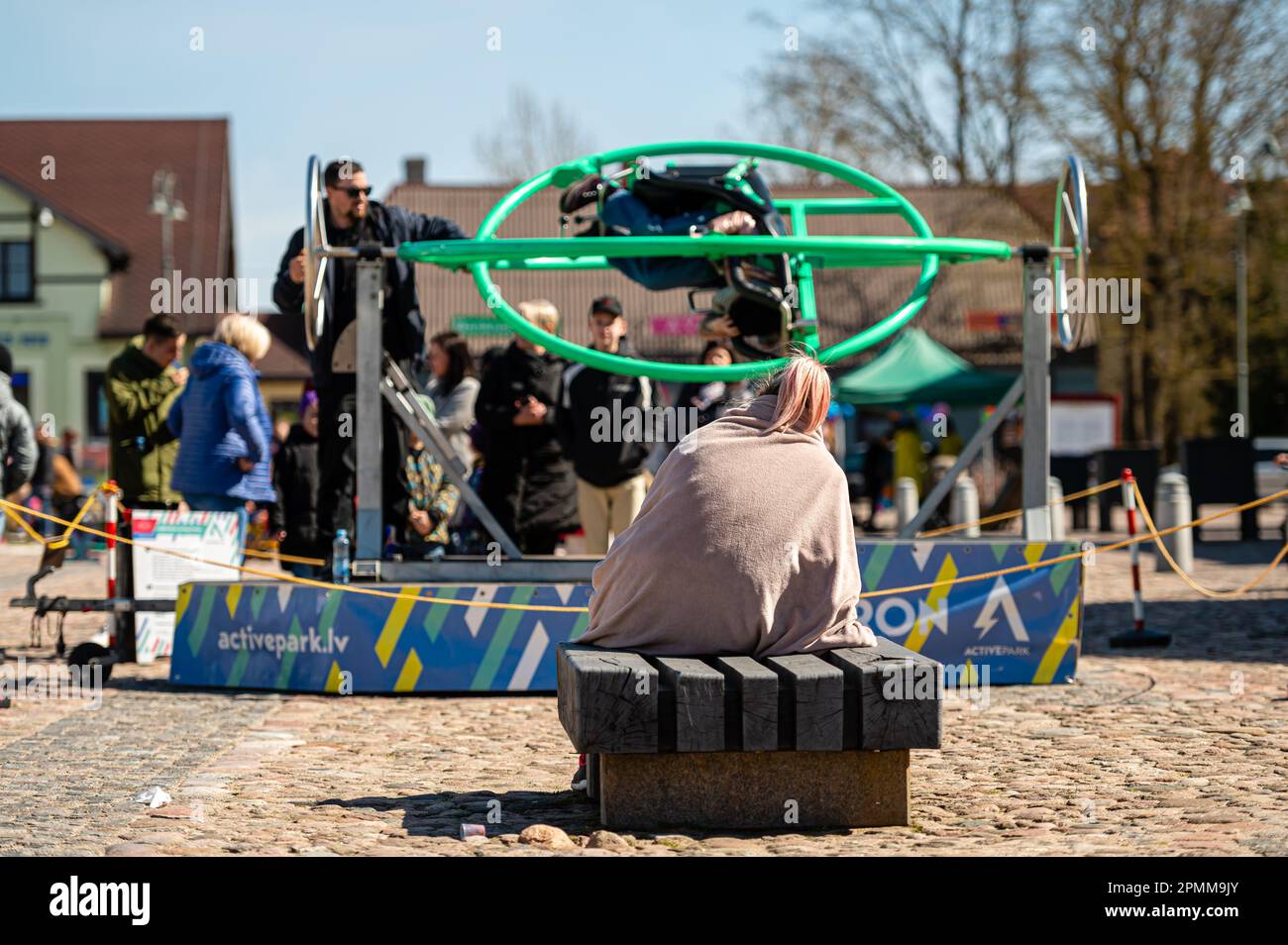 Dobele, Lettonia - 17 aprile 2022: Attrazioni portatili nella piazza della città, giroscopio Aerotrim-umano con un sedile, chiamato anche 3D swing Foto Stock