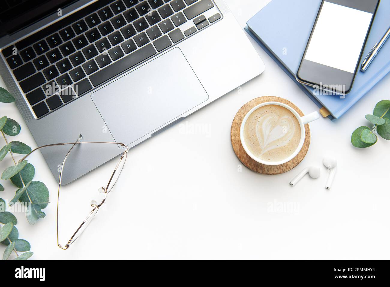 Tavolo da ufficio bianco con computer portatile, forniture e caffè. Spazio per il testo Foto Stock