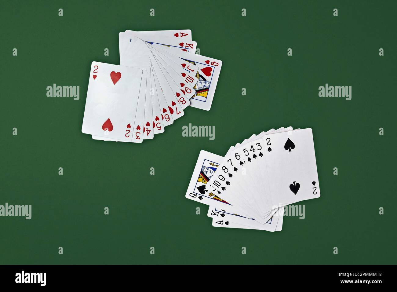 Mazzo di carte da gioco su sfondo verde. Le carte dei cuori e delle picche sono disposte in un ventilatore. Vista dall'alto. Spazio di copia. Messa a fuoco selettiva. Foto Stock