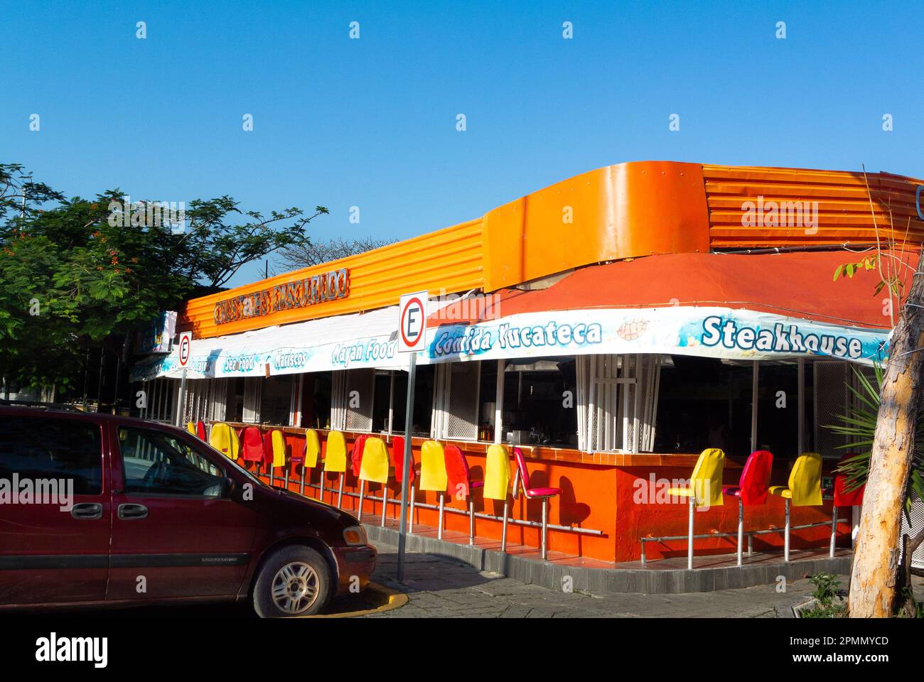 Cancun, Quintana Roo, Messico, Un banco di Steakhouse colorata con sedie nel centro di Caucun. Foto Stock