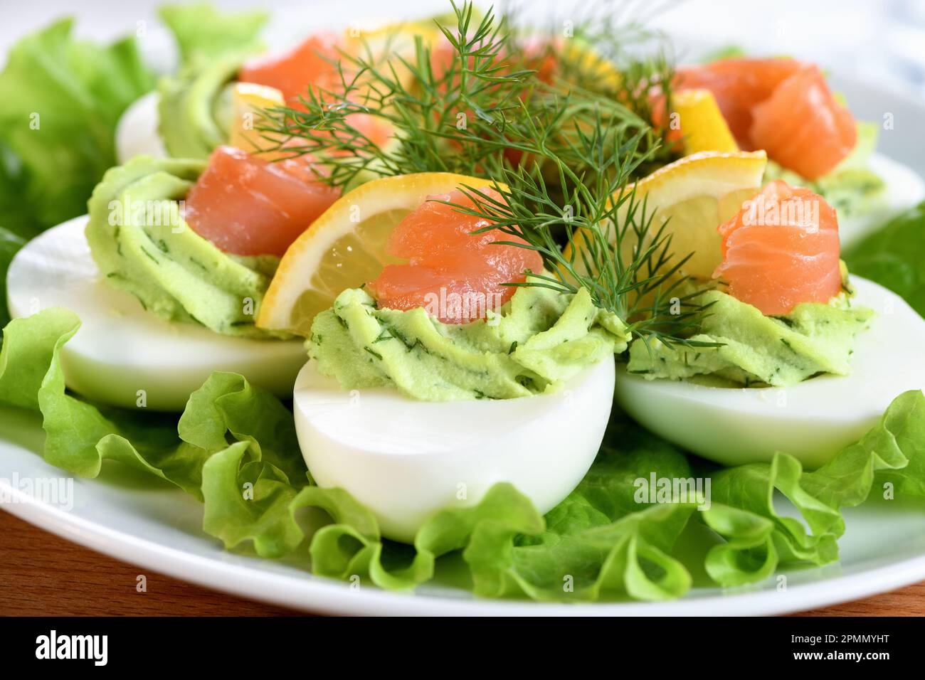 Uova farcite con avocado, salmone e limone. L'antipasto perfetto per il vostro tavolo di vacanza. Foto Stock