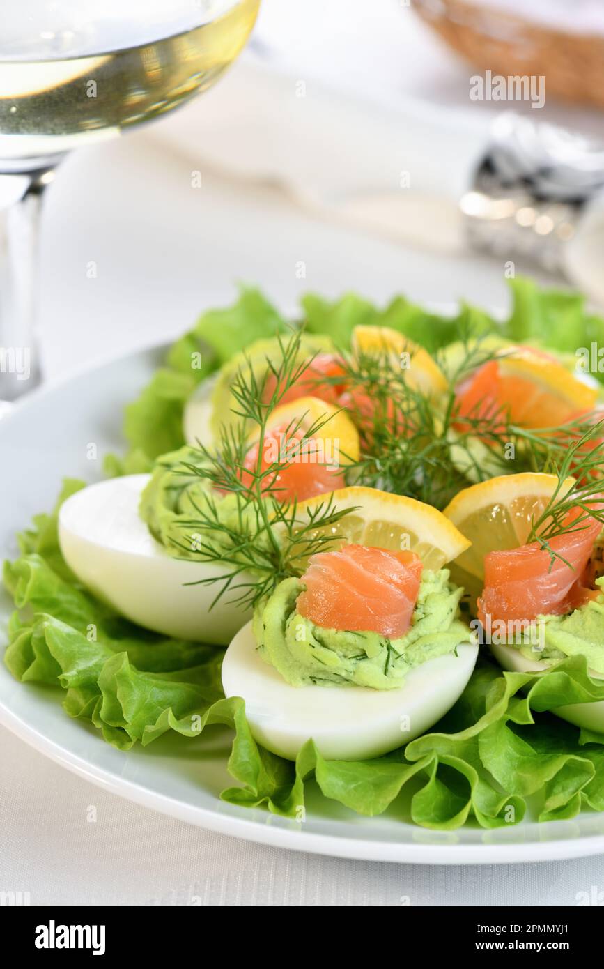 Uova farcite con avocado, salmone e limone. L'antipasto perfetto per il vostro tavolo di vacanza. Foto Stock