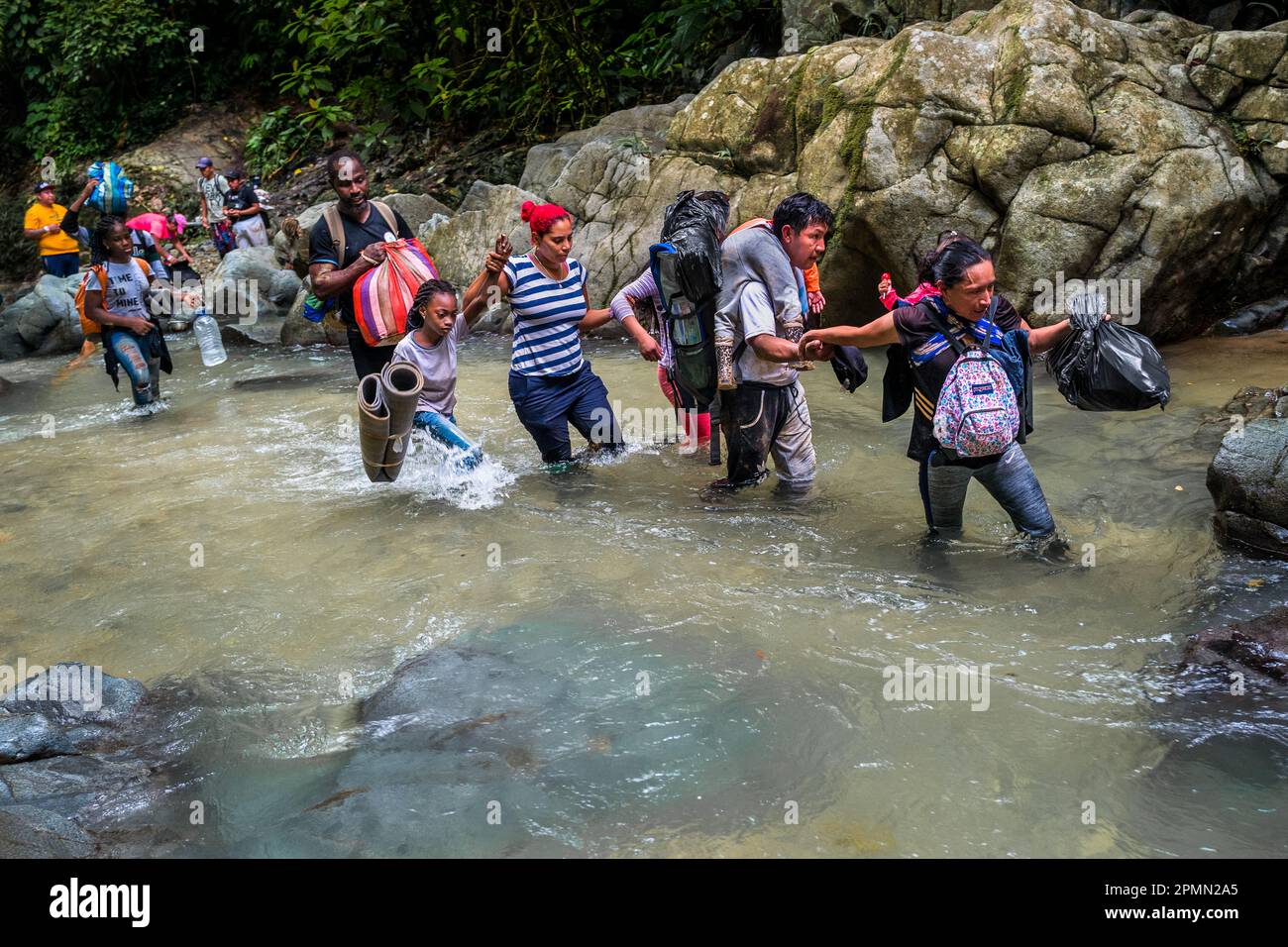 I migranti provenienti da Ecuador, Haiti e Nigeria si gualano attraverso il fiume nella selvaggia e pericolosa giungla del Darién Gap tra Colombia e Panamá. Foto Stock