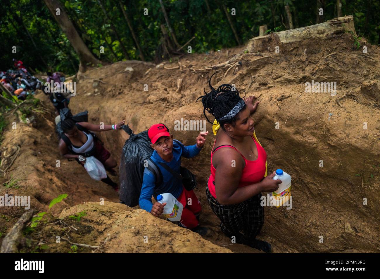 I migranti provenienti da Haiti percorrono uno stretto sentiero nella selvaggia e pericolosa giungla del Darién Gap tra Colombia e Panamá. Foto Stock